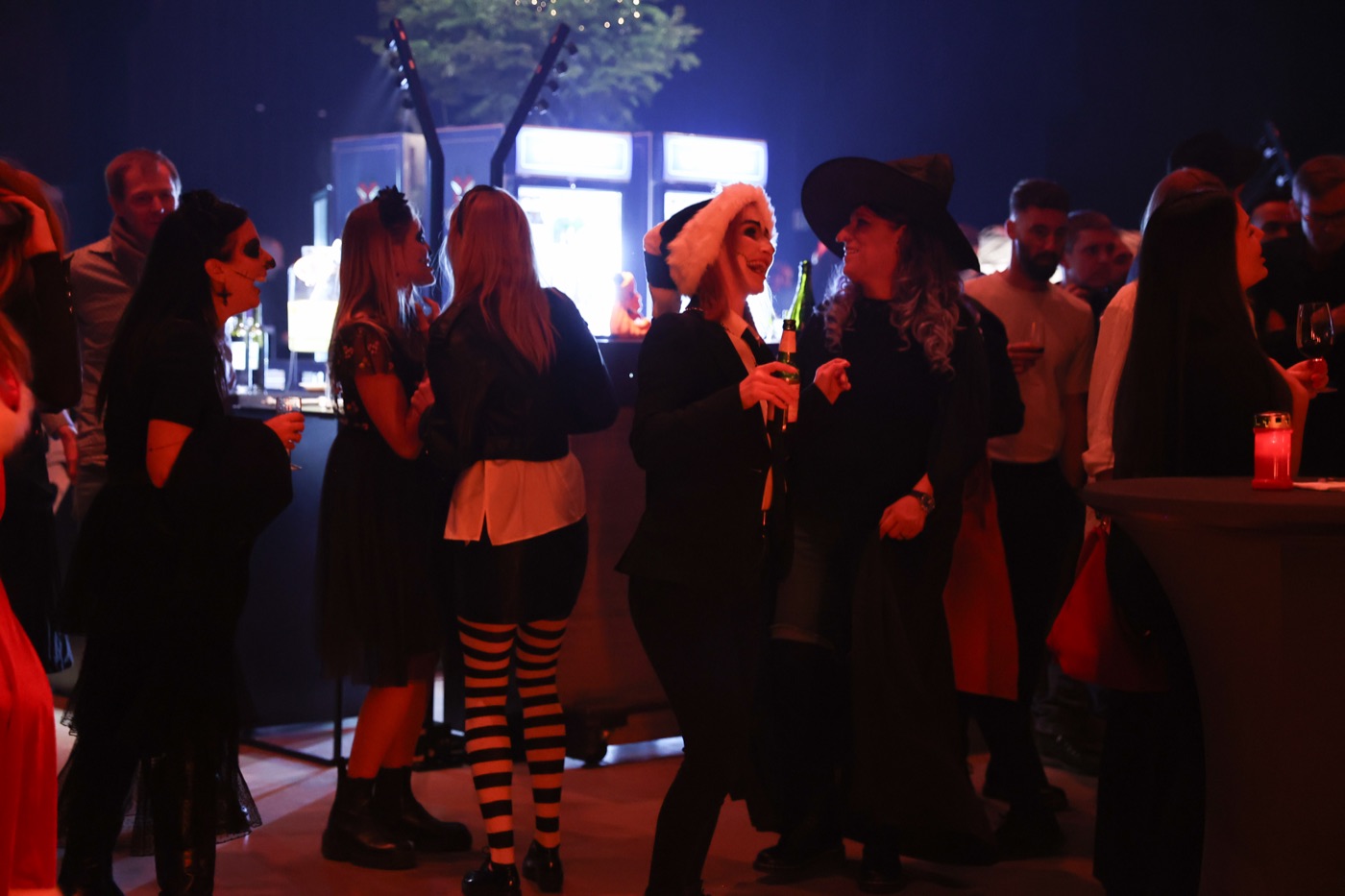 Gäste in Halloween-Kostümen zwischen den Bars
